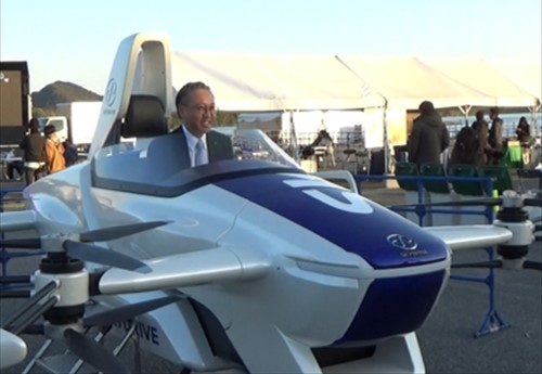 空飛ぶクルマ（模型）に試乗している様子_R